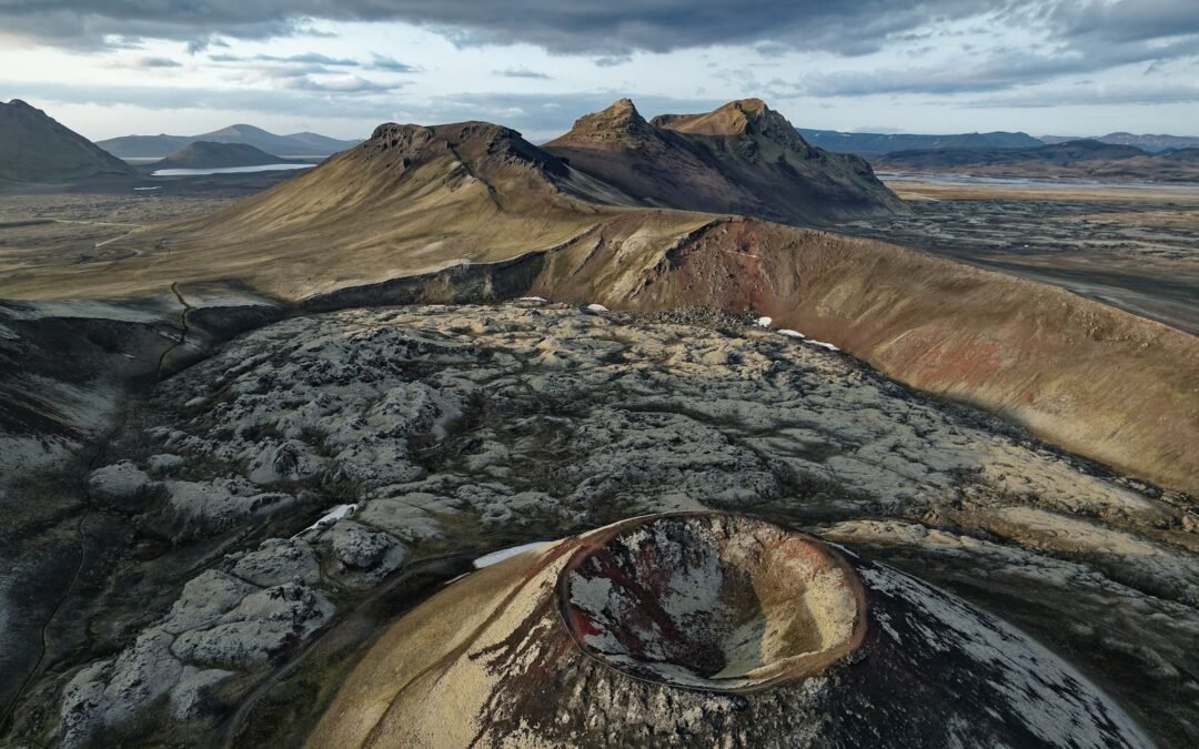 Volcanic landscape under a dramatic, cloudy sky.